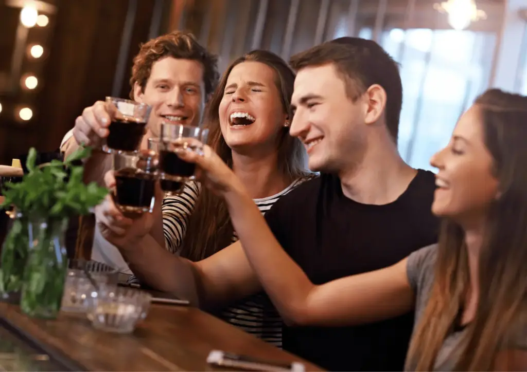 london christmas party people in a bar clinking glasses